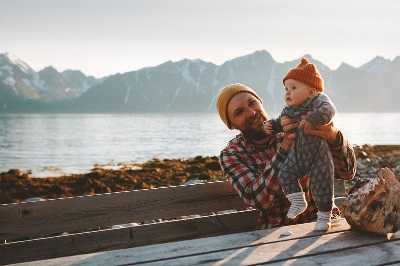 Man met baby op picknicktafel 