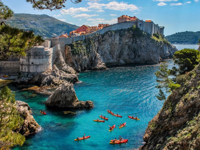 Uitzicht op de stadsmuur van Dubrovnik en varende mensen. 