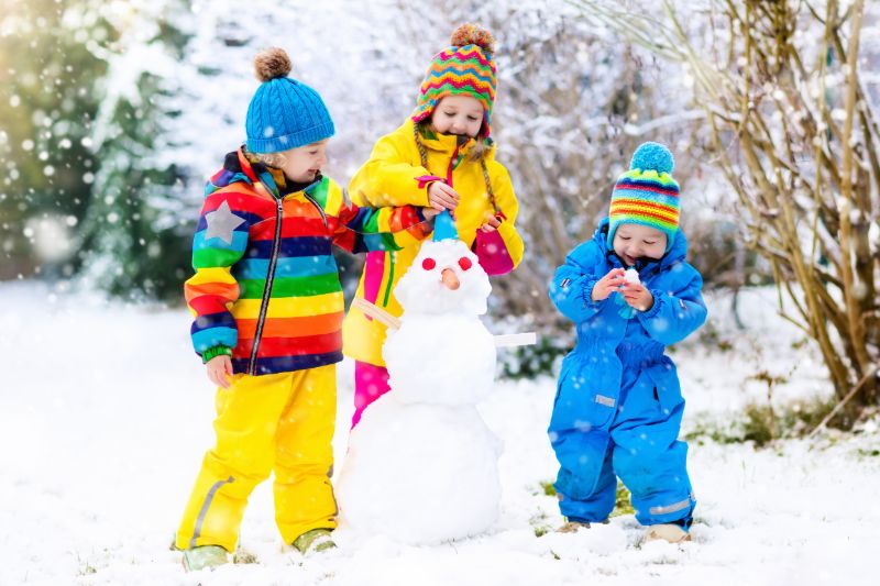 Drie kinderen bouwen een sneeuwpop