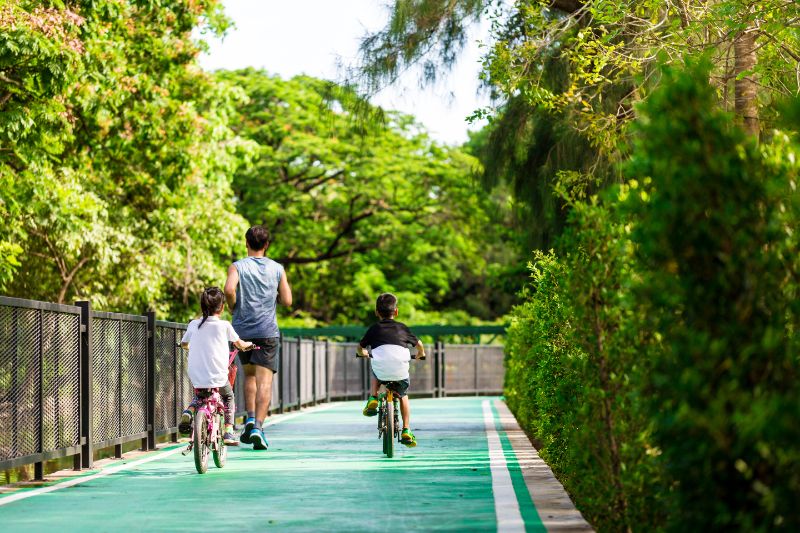 Hardlopende vader met fietsende kinderen