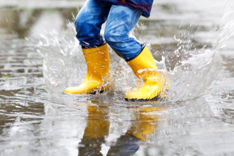 Stampen in plassen met gele laarsjes