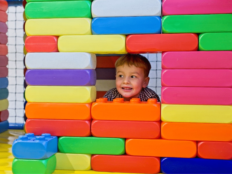 Kind in indoor speeltuin spelend met blokken
