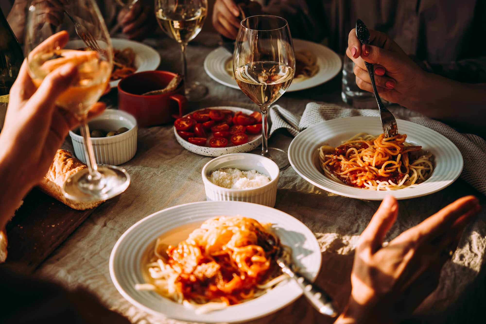 vrienden eten pasta en drinken wijn