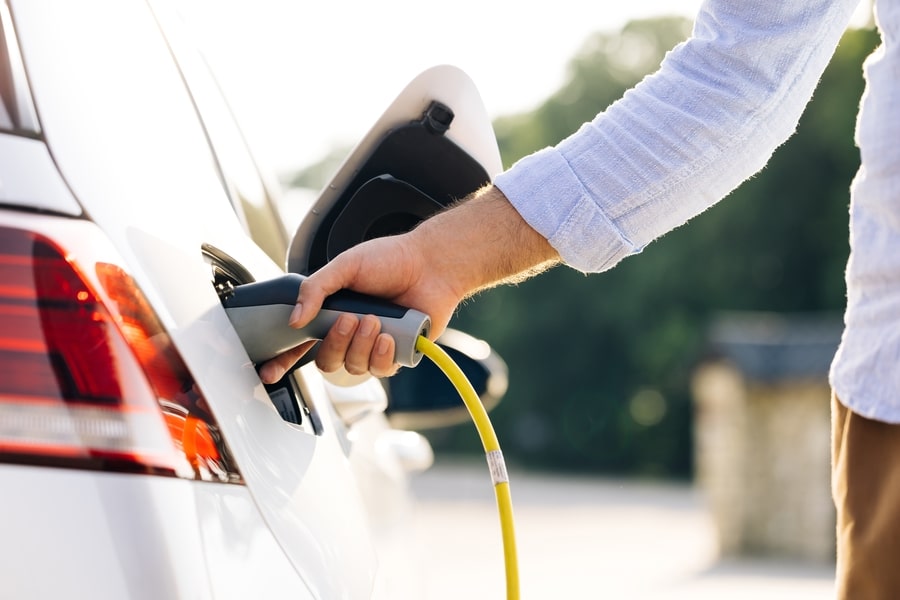 een man laadt zijn elektrische auto op