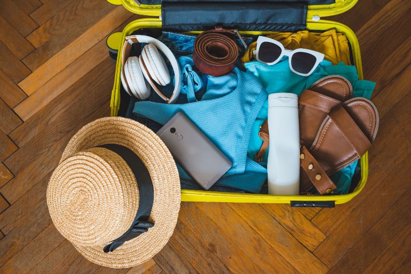 Ingepakte koffer met zomerkleding en accessoires