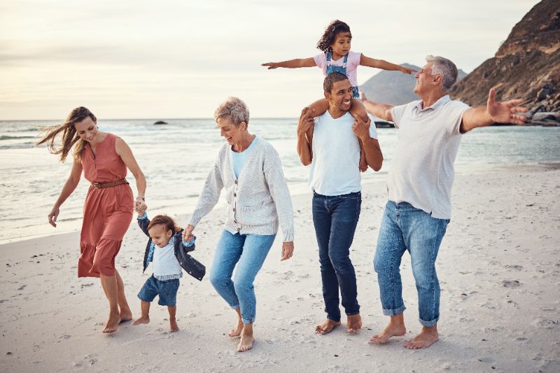 Grootouders met kinderen en kleinkinderen op het strand