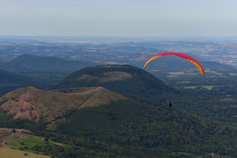paraglider met uitzicht op groene, heuvelachtige omgeving
