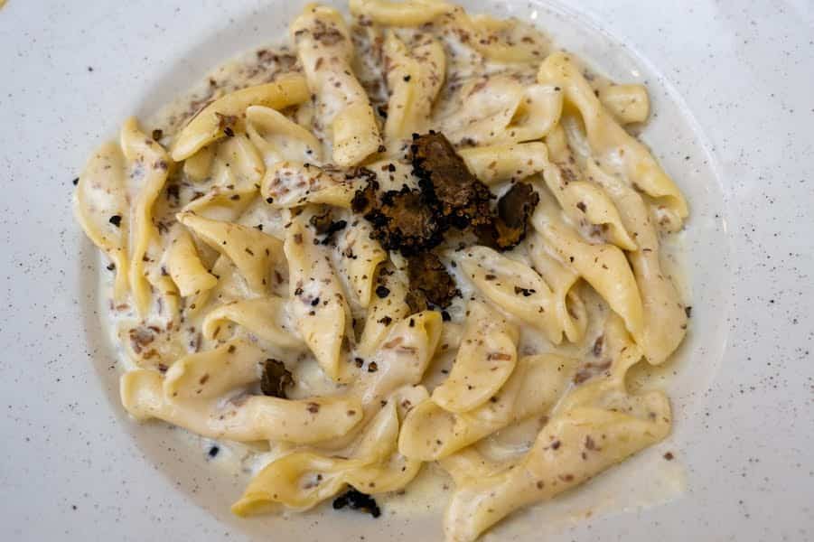 bord pasta met zwarte truffels en witte saus