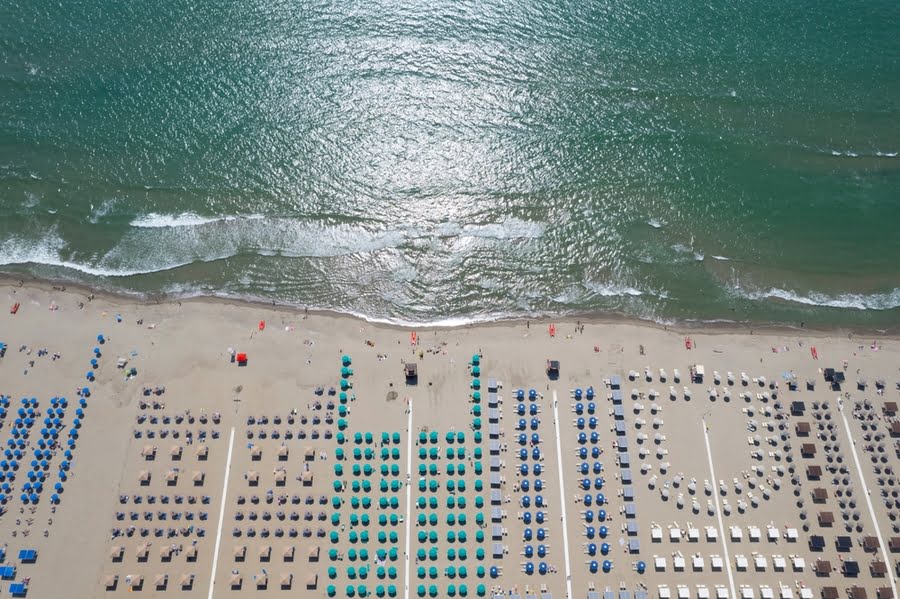 luchtfoto van strand vol bedjes en parasols